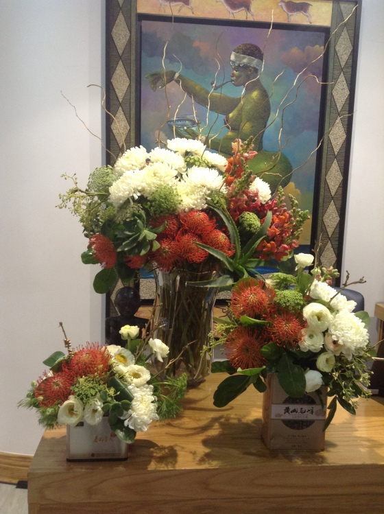 Protea, ranunculus and mum arrangements